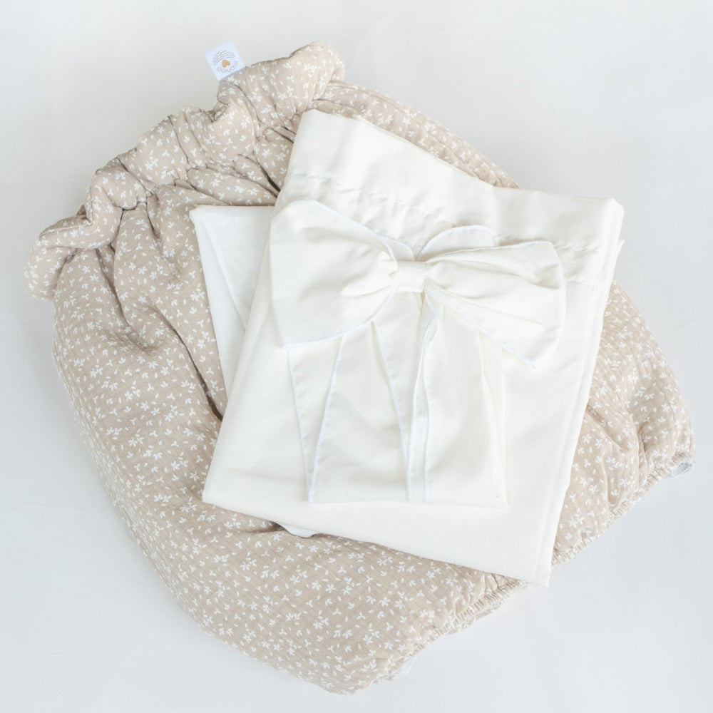 Cream-colored Stubenwagen bedding set with large decorative bow on beige floral patterned mattress pad. - Mionido - Bollerwagen Tony (natur)